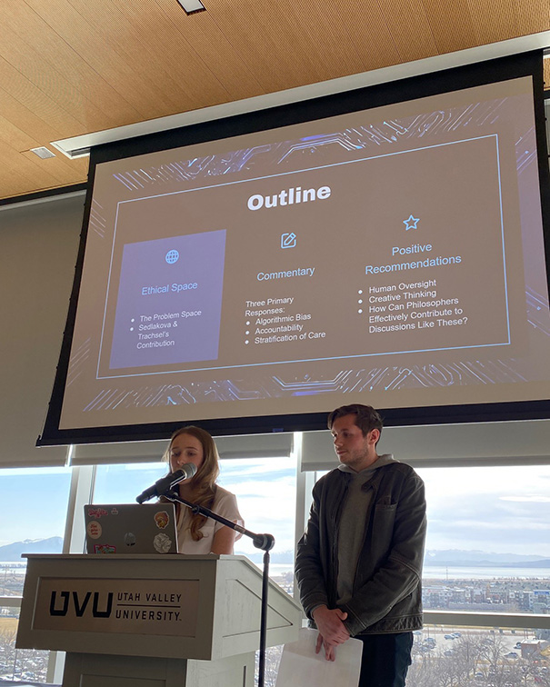 Pierce and Kalista speaking at UVU with a their presentation on a slideshow behind them.