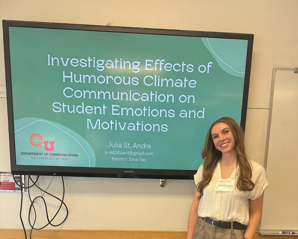 Julia standing with her research presentation