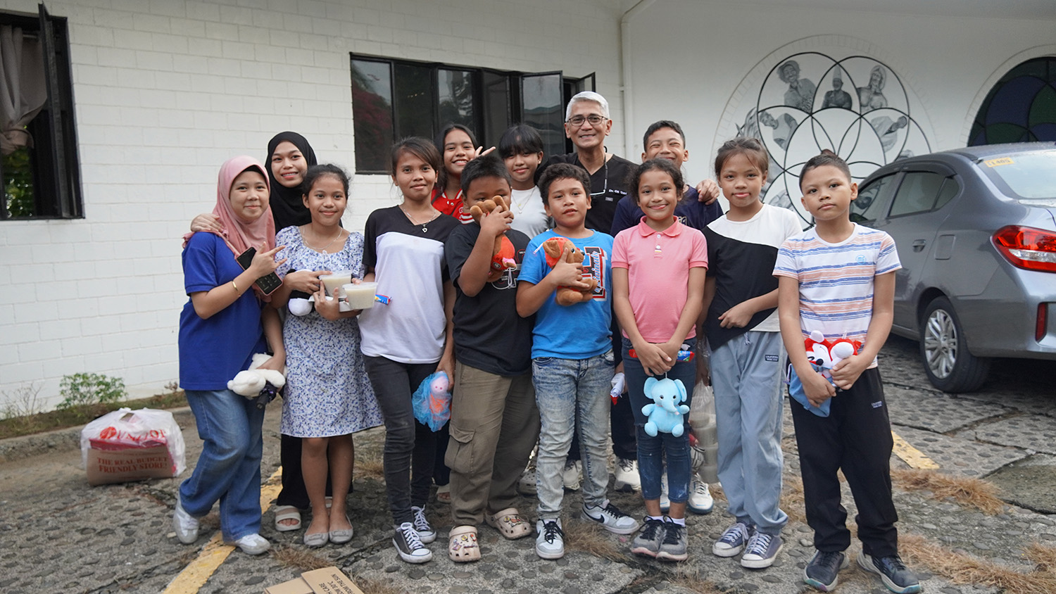 Dr. Urbi with twelve of the children who received dental care, standing outside the clinic. 