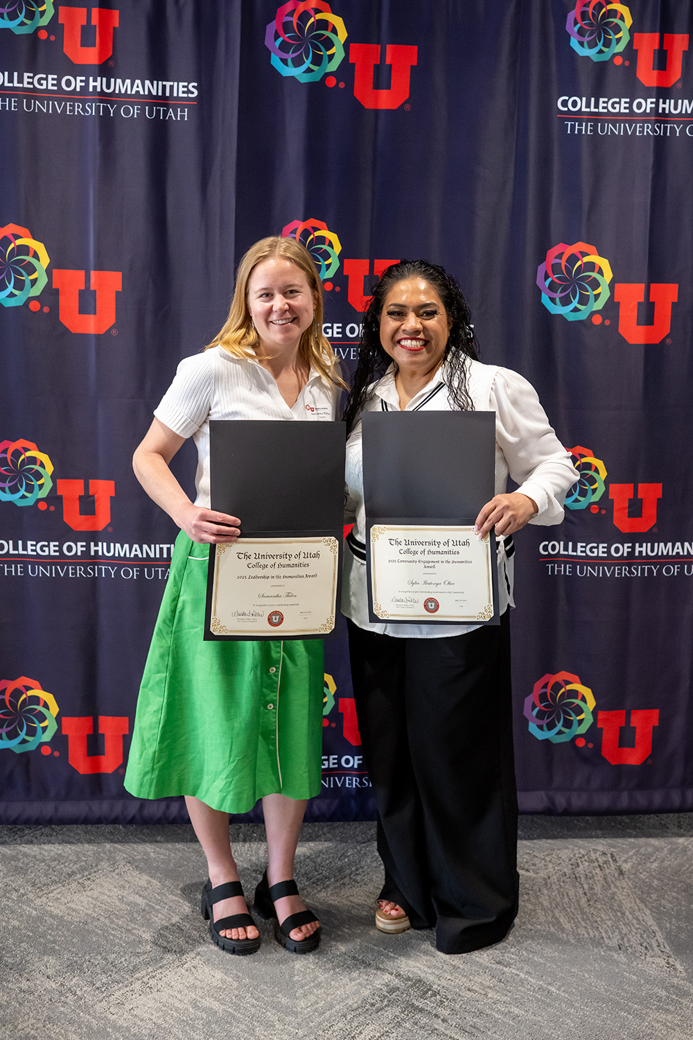 Student award winners in front of the College of Humanities photo backdrop