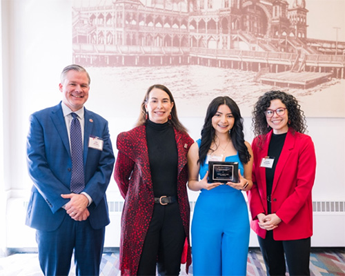 Jasmine standing with her plaque with mentor, VP of Research, and Dean