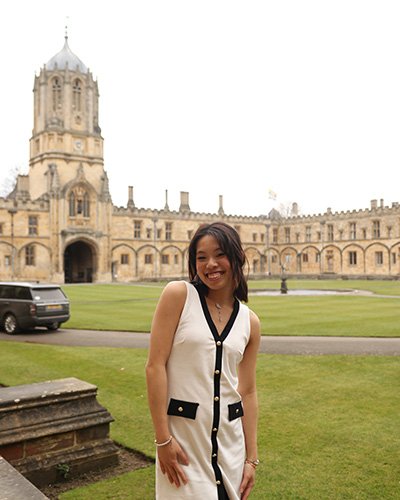 Wen standing in a white dress and smiling at the camera