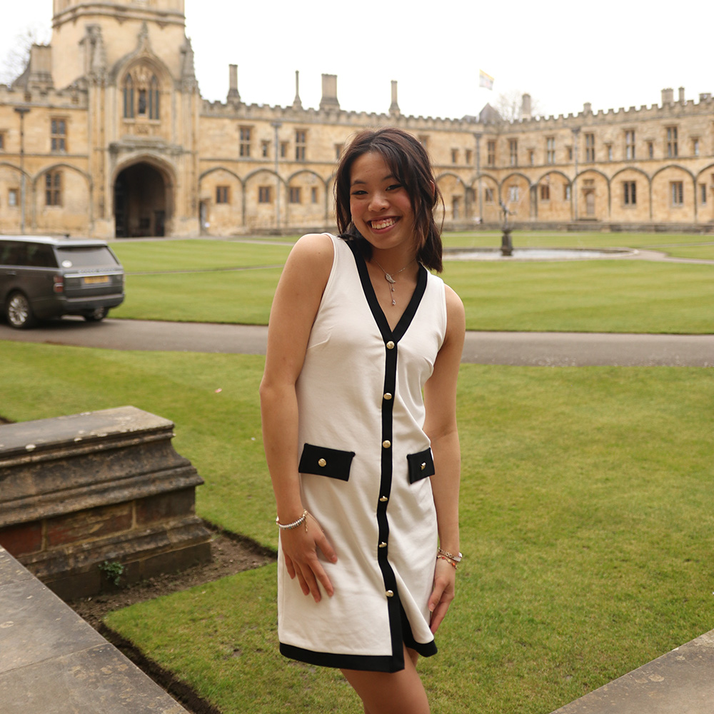 Wen Lee sending in front of an old building smiling at the camera