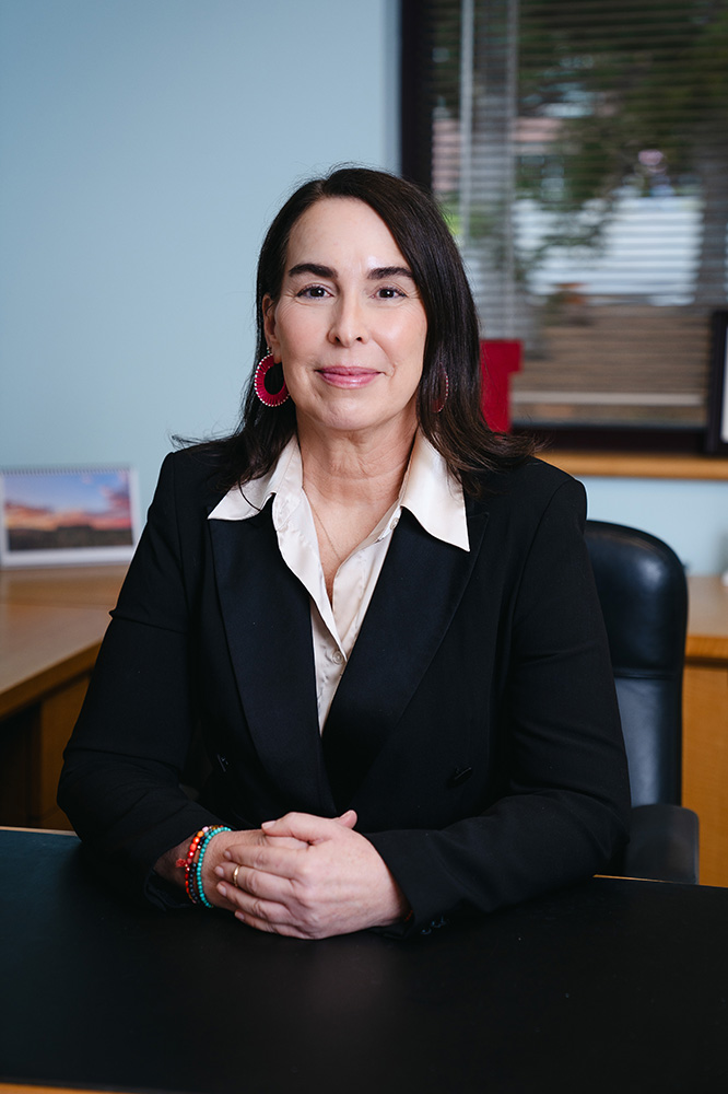 Wanda Pillow looks at the camera, seated at her desk