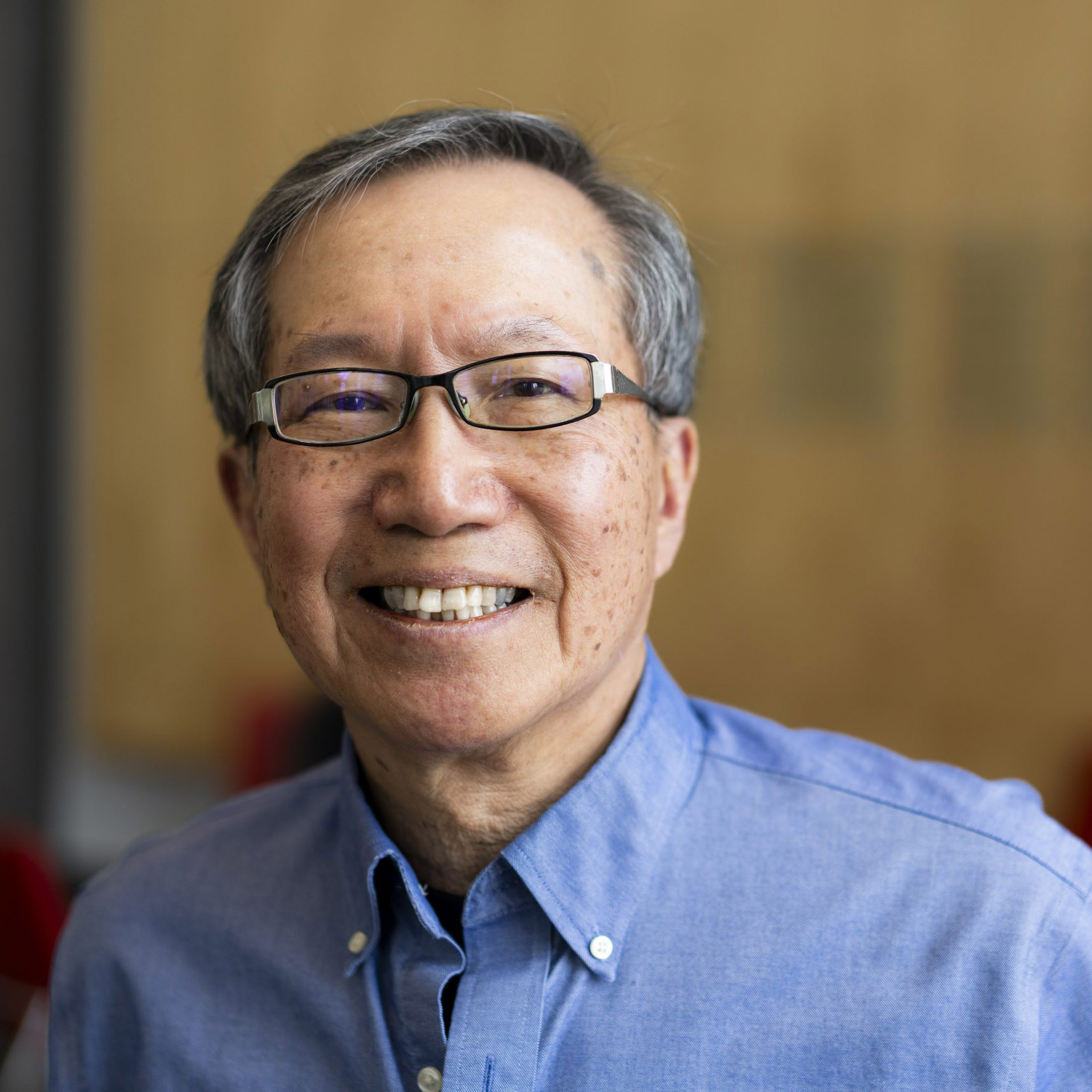 Headshot of Vincent Cheng smiling at the camera wearing a light blue button down