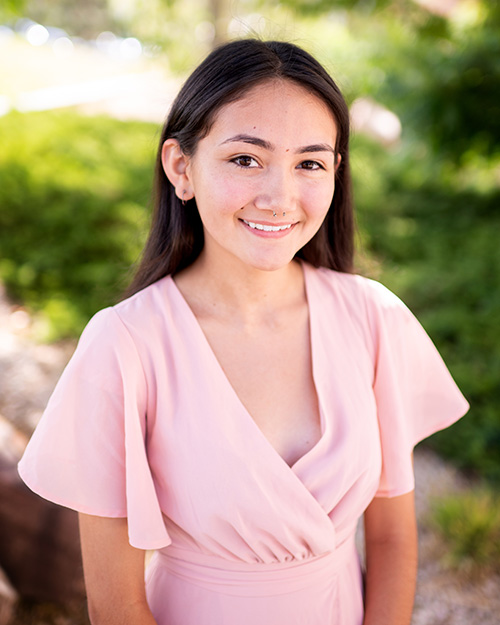 Allie smiling at the camera with a pink dress