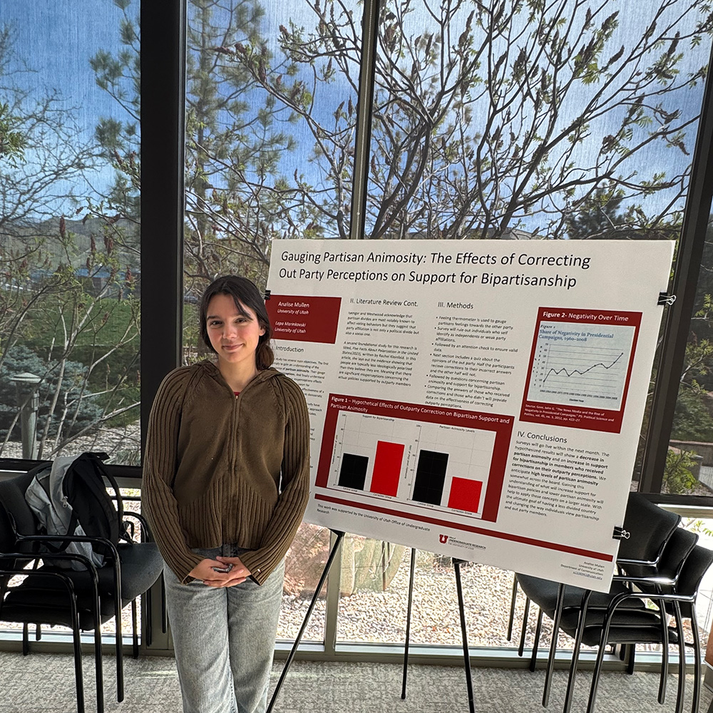 Analise standing with her research poster on the right-side of her.