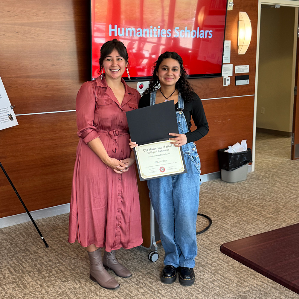 Lepa and Bhavika standing together and smiling at the camera. Bhavika is holding a certificate.