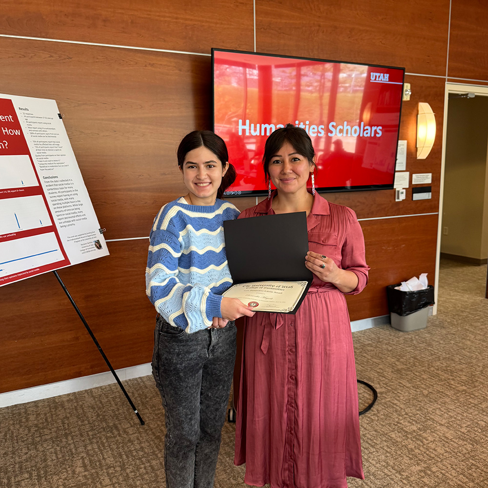 Lepa and Dominika standing together and smiling at the camera. Dominika is holding a certificate.