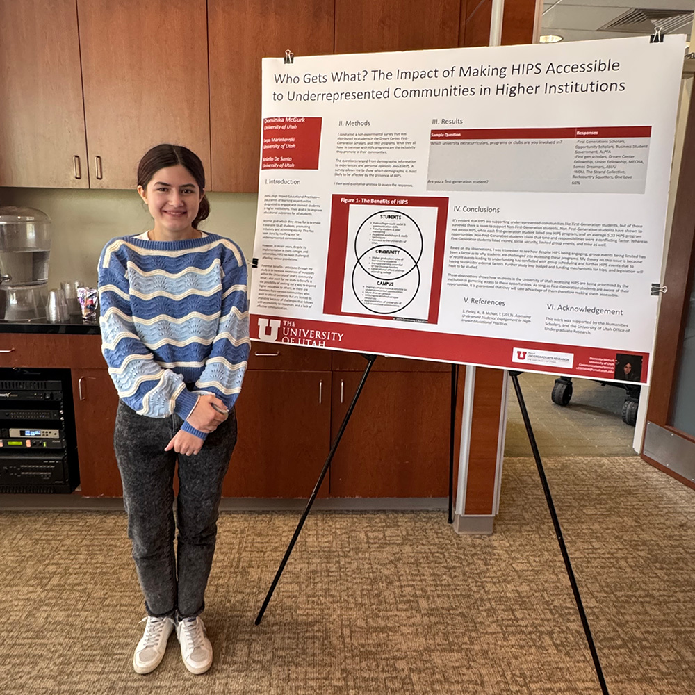 Dominika standing with her research poster on the left-side of her.