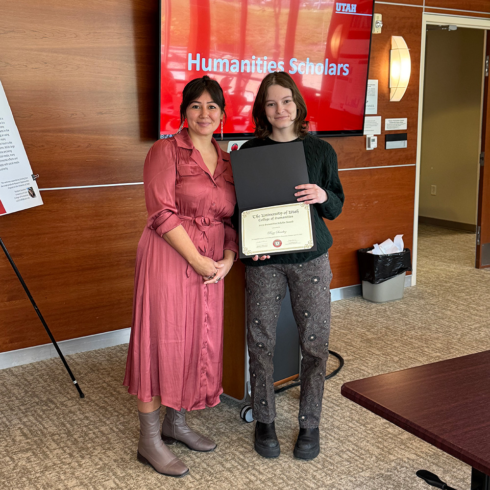 Lepa and Rozz standing together and smiling at the camera. Rozz is holding a certificate.