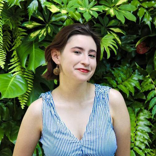 Young woman with very short dark hair and blue striped blouse 