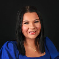 Young woman with short black hair and blue dress