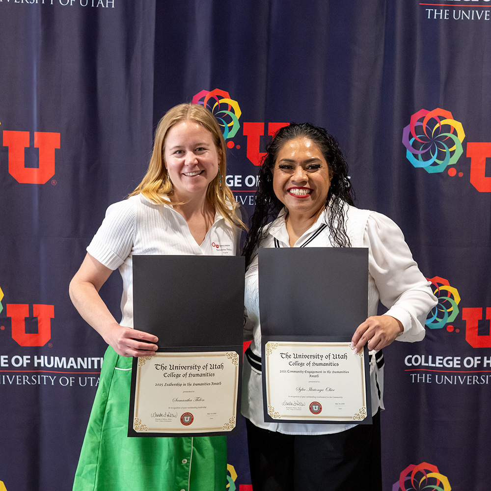 2 women, each holding an award