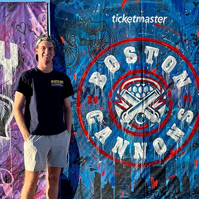 Cameron standing next to a Boston Cannons sign