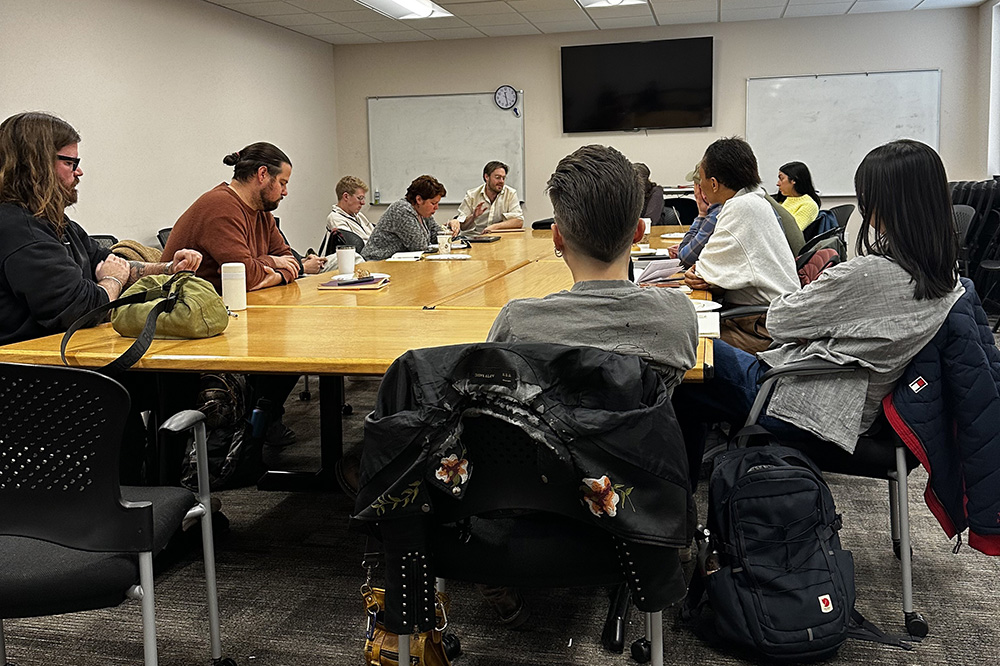 graduate students around a table in a meeting