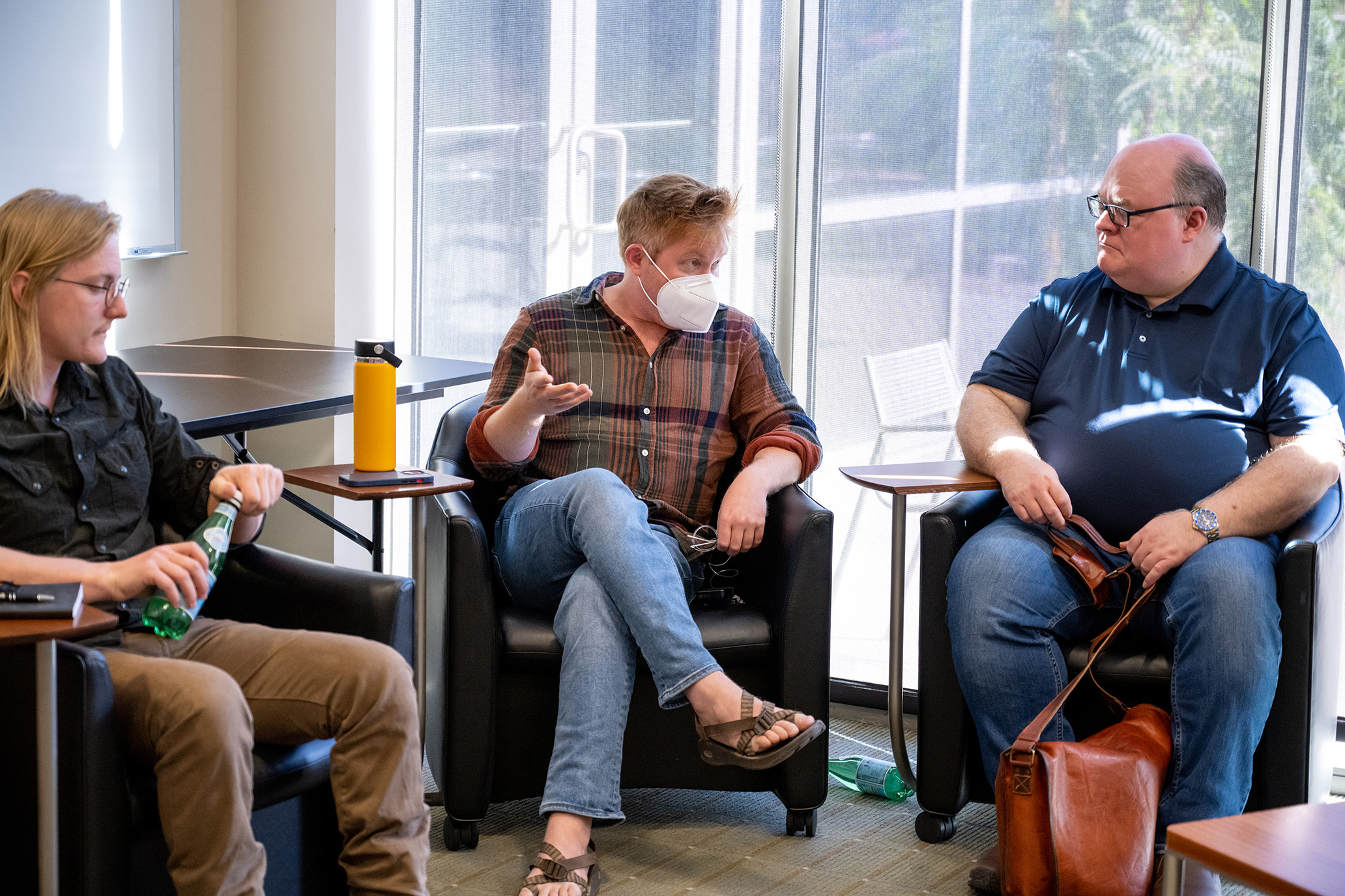 Three fellows sitting and having a discussion